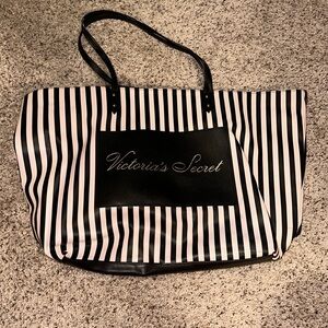 Striped tote with magnetic clutch and front pocket.